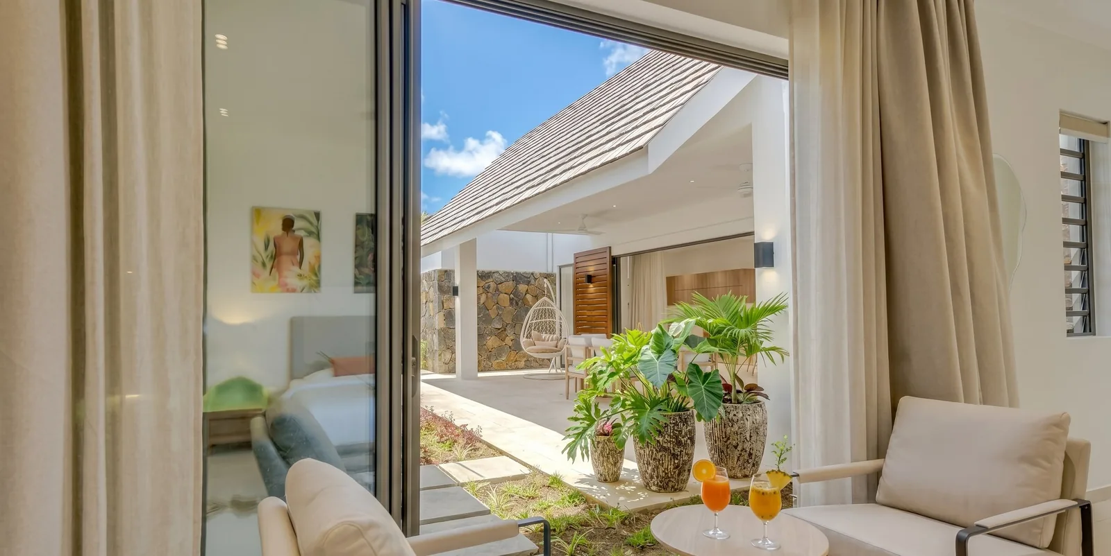 Chambre principale de la Villa Easile avec lit king-size et triptyque d'art tropical